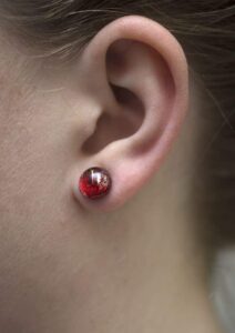 Interstellar red stud earrings on a model